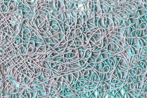 Randomly scattered knitting threads in gray and turquoise colors. Knitting, needlework, tangled threads.