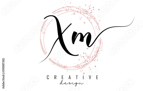 Handwritten XM X M letter logo with sparkling circles with pink glitter.
