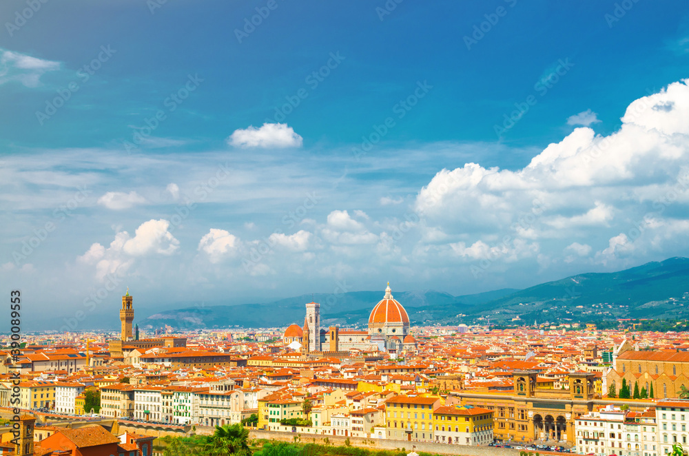 Fototapeta premium Top aerial panoramic view of Florence city with Duomo Cattedrale di Santa Maria del Fiore cathedral, buildings houses with orange red tiled roofs and hills range, blue sky white clouds, Tuscany, Italy