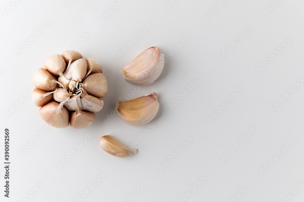 Garlic cloves and pieces of raw garlic on isolated white background. Top view Garlic bulbs with blank space. Garlic cloves and pieces of raw garlic on isolated white background. Top view Garlic bulbs with blank space.