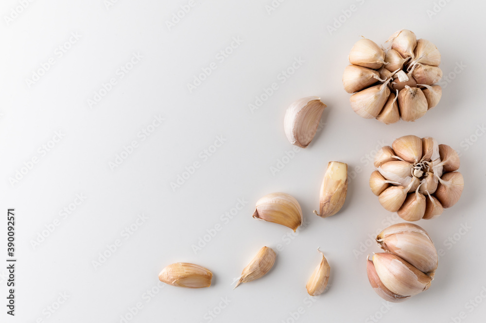 A lot of Garlic cloves and pieces of raw garlic on isolated white background. Top view Garlic bulbs with blank space. A lot of Garlic cloves and pieces of raw garlic on isolated white background. Top view Garlic bulbs with blank space.