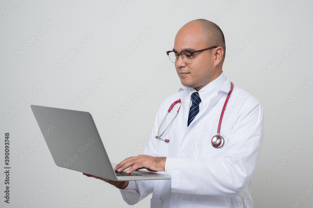 Physician in white coat, stethoscope working with laptop isolated on white.background. Physician in white coat, stethoscope working with laptop isolated on white.background.