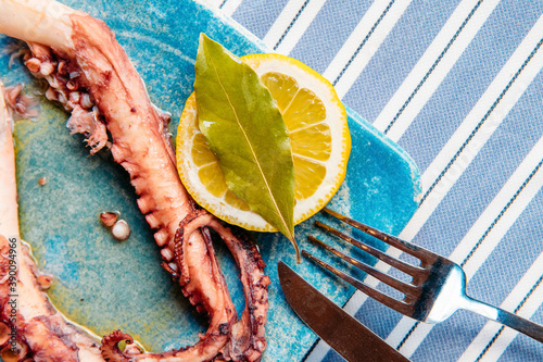 Fototapeta Naklejka Na Ścianę i Meble -  Grilled, fried or roasted octopus appetizer meal in Greek or Turkish Fish Restaurant on the table for dinner or lunch at the beach from Greece or Turkey. Seafood, meze or appetizer for dinner.