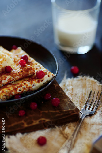 National Russian food. Pancakes in a frying pan with milk. Rustic stylization