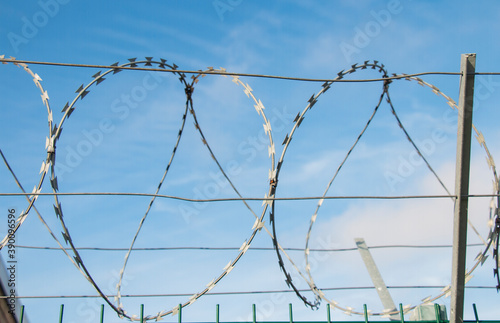 Barbed wire fence on european and world border on blue sky background sunny day, closed borders concept