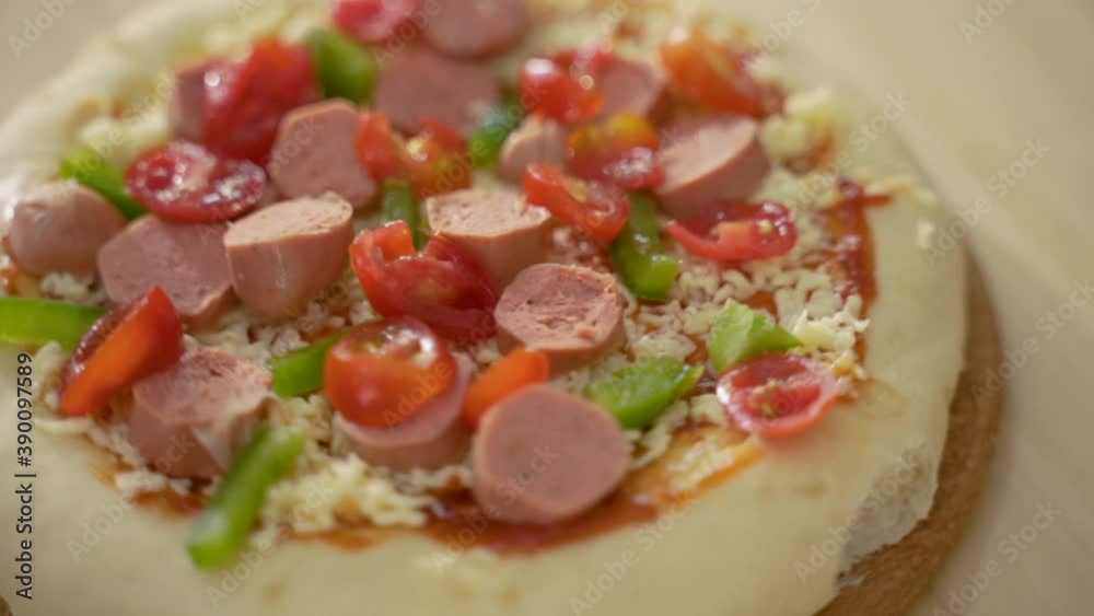 close up of pizza making with topping of paprika, cheese and sausage close up of pizza making with topping of paprika, cheese and sausage