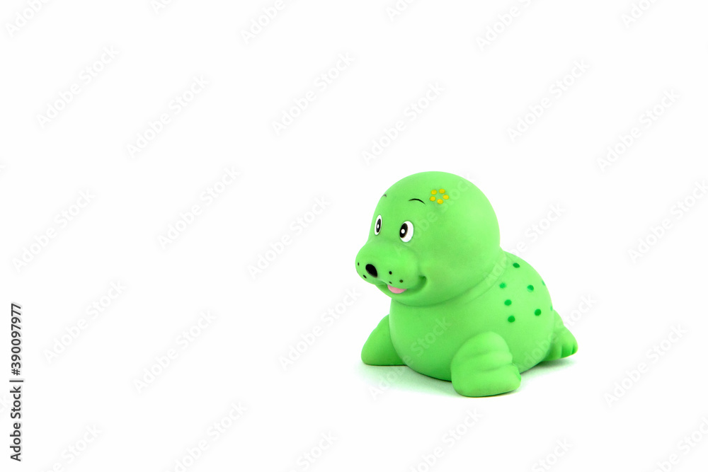 Green rubber seal or fur seal for playing in the bathroom by a child on a white background. Water toy. Child development Green rubber seal or fur seal for playing in the bathroom by a child on a white background. Water toy. Child development
