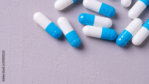 white and blue pills on a gray background. medical background