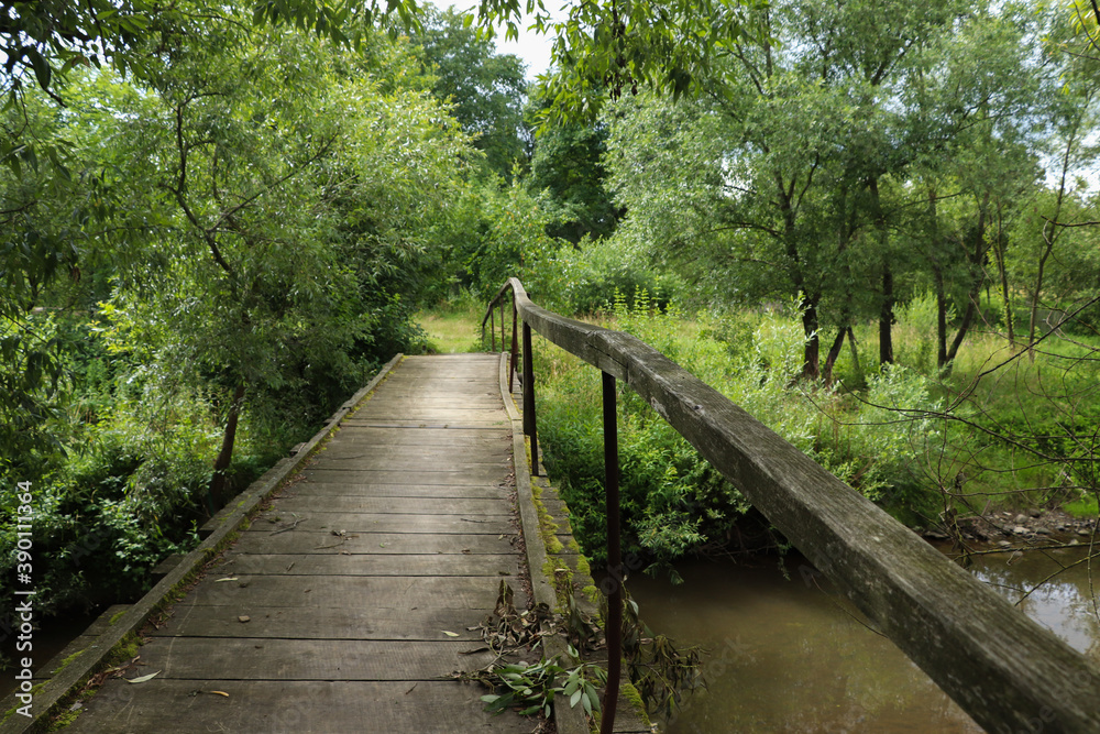 A rural bridge leads through the river to the village. A rural bridge leads through the river to the village.