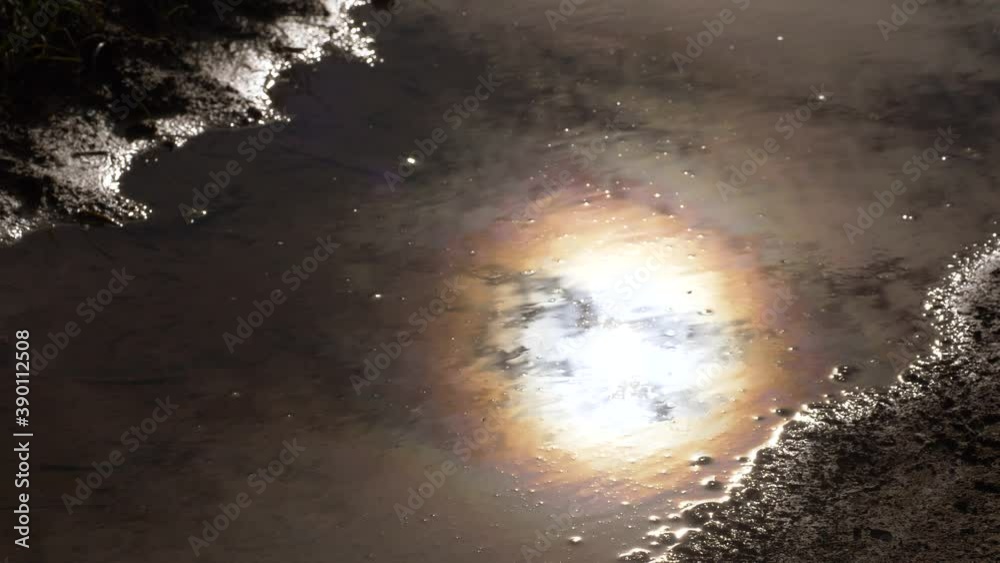 Beautiful full moon reflection in small water puddle during wet autumn night.Top down slider.