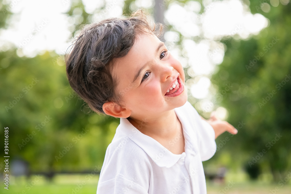 Happy funny adorable boy dancing, laughing, having fun in summer park, smiling and looking away. Closeup shot. Childhood concept Happy funny adorable boy dancing, laughing, having fun in summer park, smiling and looking away. Closeup shot. Childhood concept