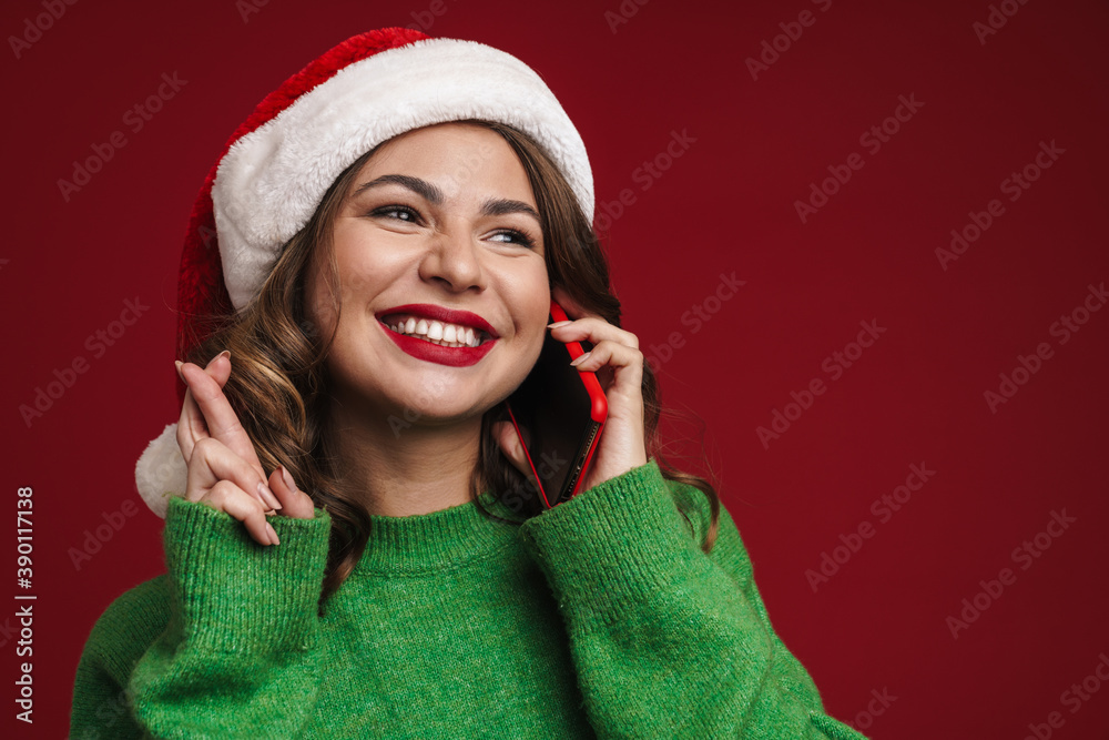 Woman in christmas santa hat talking by mobile phone Woman in christmas santa hat talking by mobile phone