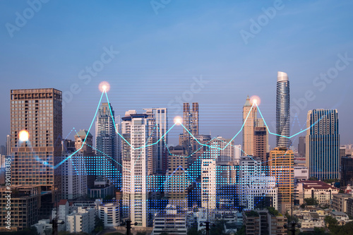 Market behavior graph hologram  sunset panoramic city view of Bangkok  popular location to achieve financial degree in Asia. The concept of financial data analysis. Double exposure.