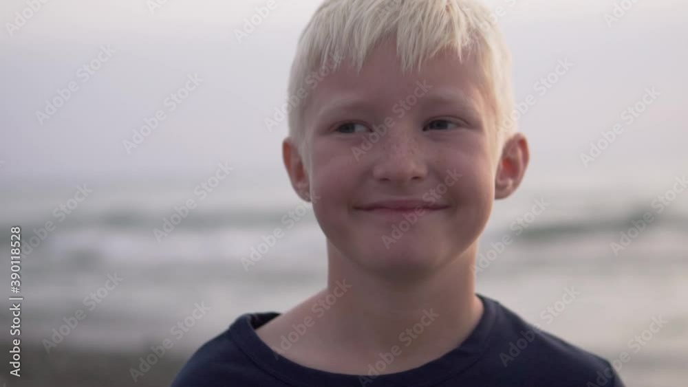 Close-up boy blond smiles against the backdrop of the washed-out sea at sunset. A child on vacation in Sochi. Close-up boy blond smiles against the backdrop of the washed-out sea at sunset. A child on vacation in Sochi.