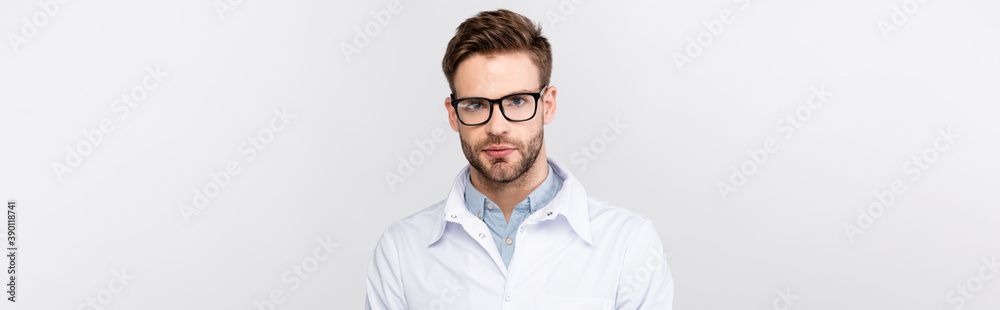 Doctor in eyeglasses looking at camera isolated on grey, banner Doctor in eyeglasses looking at camera isolated on grey, banner