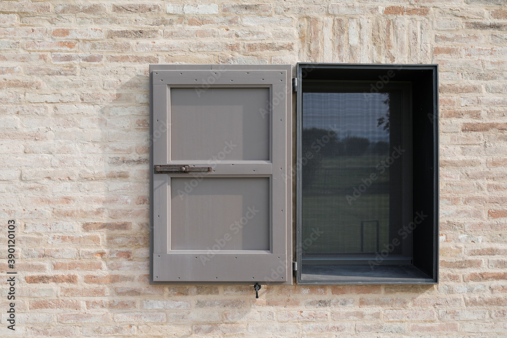 window with grey open shutter on a brick wall, space for text and no person