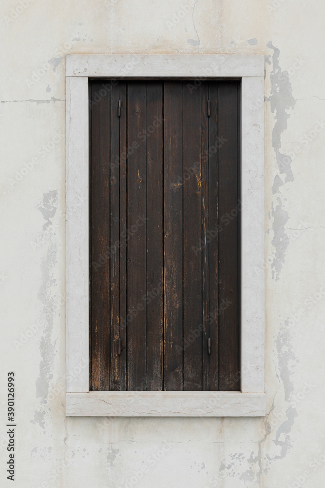 old window with wooden shutters, white wall with cracked and peeled, vertical format with space for text