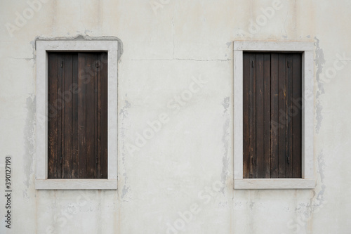  two old window with wooden shutters on a bright wall, no person an space for text, horizontal 