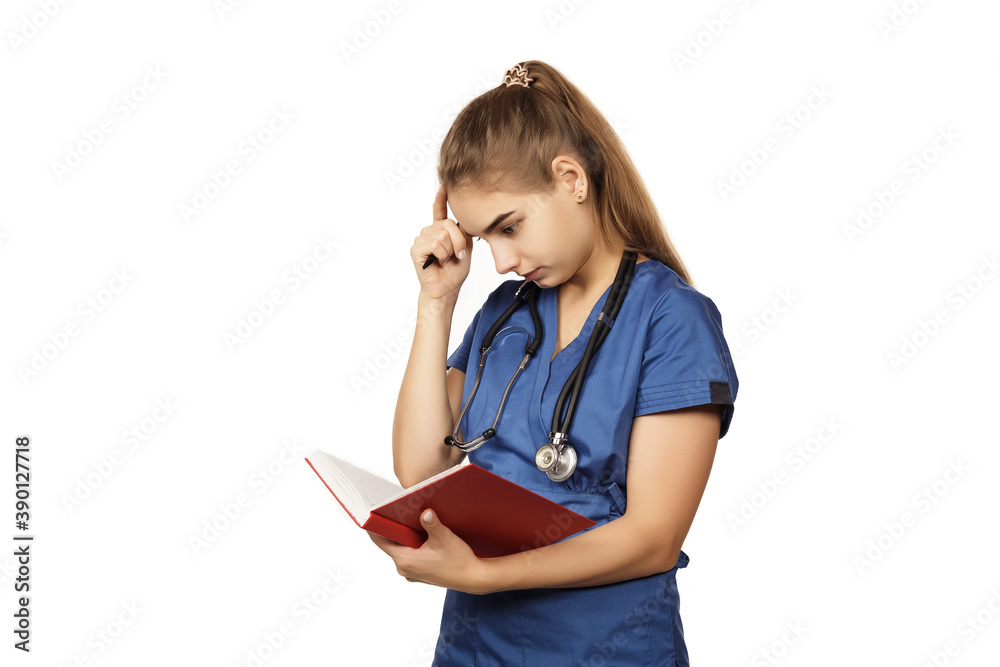Young beautiful woman doctor in blue surgical gown with stethoscope and red notebook writes anamnesis isolated on white background. Copspace Young beautiful woman doctor in blue surgical gown with stethoscope and red notebook writes anamnesis isolated on white background. Copspace