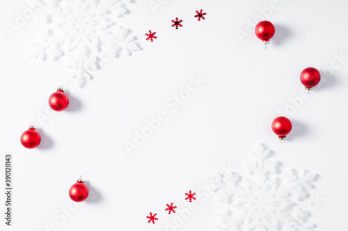 Christmas minimal holiday composition. Frame made of snowflakes and red decorations on white background. Christmas, New Year, winter concept. Flat lay, top view, copy space