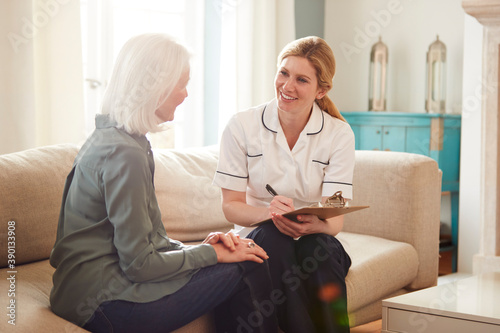 Female Doctor Making Home Visit To Senior Woman For Medical Check