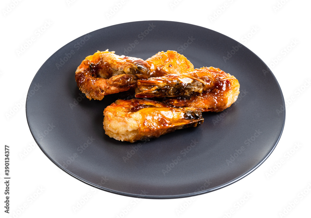 several fried tiger prawns on black plate isolated on white background several fried tiger prawns on black plate isolated on white background