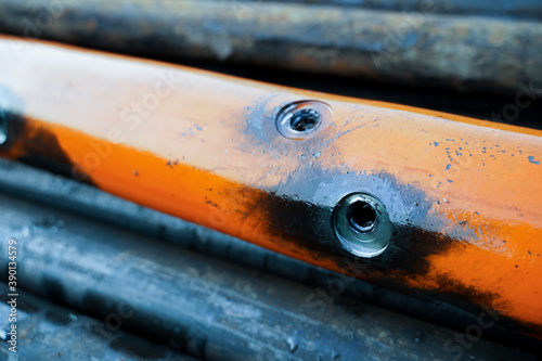 Perforation tool for perforate oil and gas well to make the hole on production tubing to allow gas and condensate flow. Close up image of perforated gun carrier. Perforating gun swelling after firing. photo