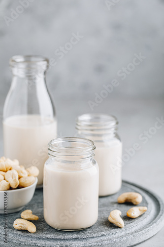 Cashew Nut Milk in glass on gray stone background