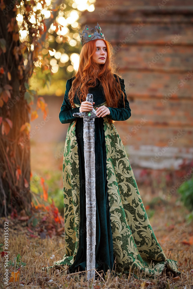 Queen with red hair in a green dress with a crown and a sword
