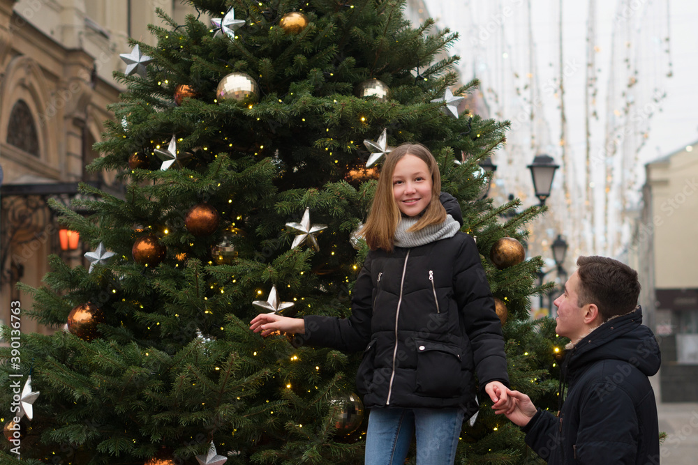 Brother and sister are walking on Christmas Eve in the city streets. Merry Christmas and Happy Holidays. Family for a walk