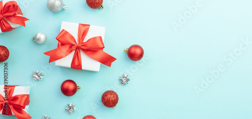 Two white gift boxes with red and silver ornaments on blue background. Christmas background. Flat lay  top view  copy space. Banner. 