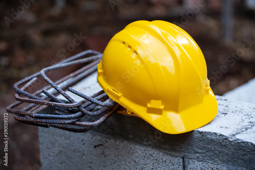 Construction hard hat safety tools equipment for workers in construction site for engineering protection head standard on building construction background. Yellow helmet.