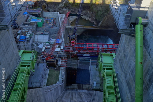 Under construction of a hydroelectric power plant. The blue sky and the autumnal mountains. Japanese landscape. Beautiful autumn scenery.