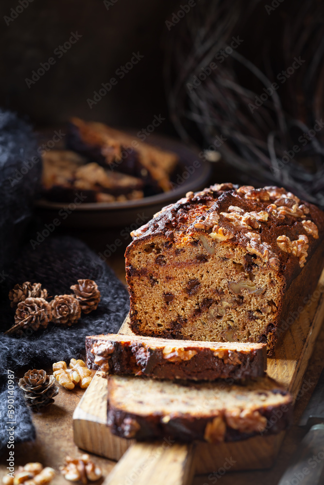 Fototapeta premium Delicious homemade chocolate and walnut gluten free banana bread sliced on wooden bread