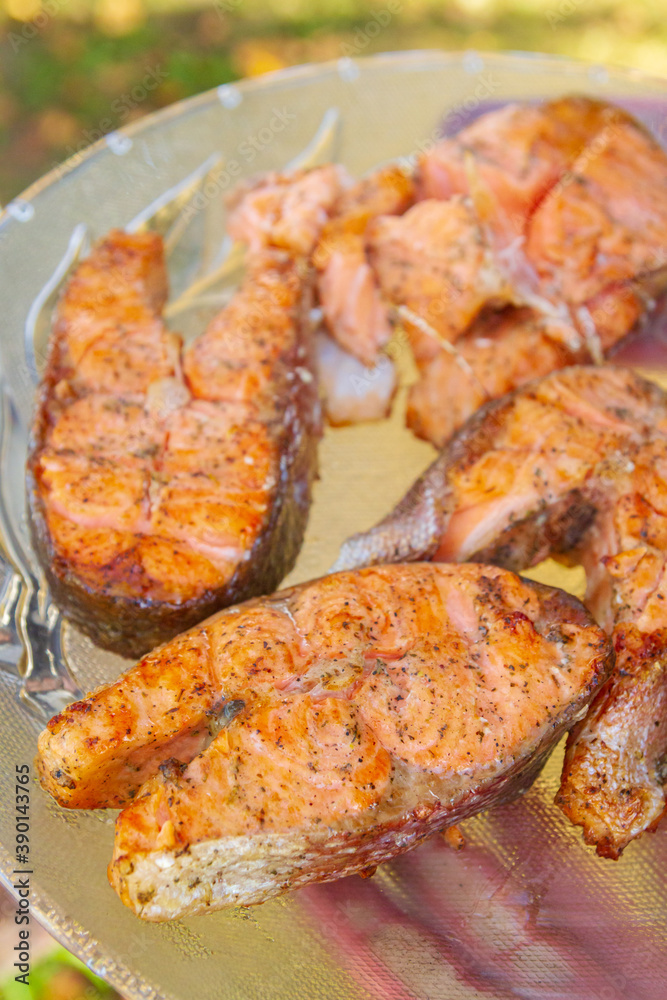 Grilled red fish trout steaks lie on a glass plate