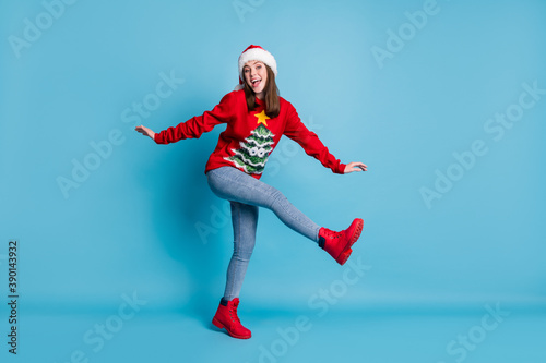 Full body size photo of cute pretty lady raise hands leg flirty girlish open mouth wear santa x-mas headwear red ornamented sweater boots jeans isolated blue color background