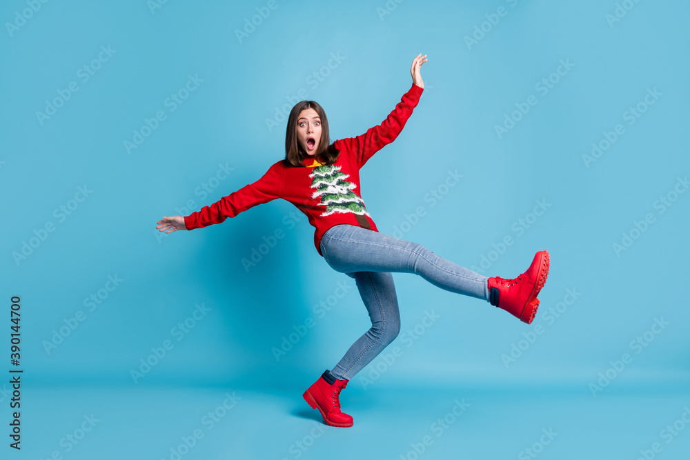 Full length photo of cute charming funky lady stand tiptoe raise hands leg falling open mouth staring afraid funny look wear red sweater jeans boots isolated blue color background