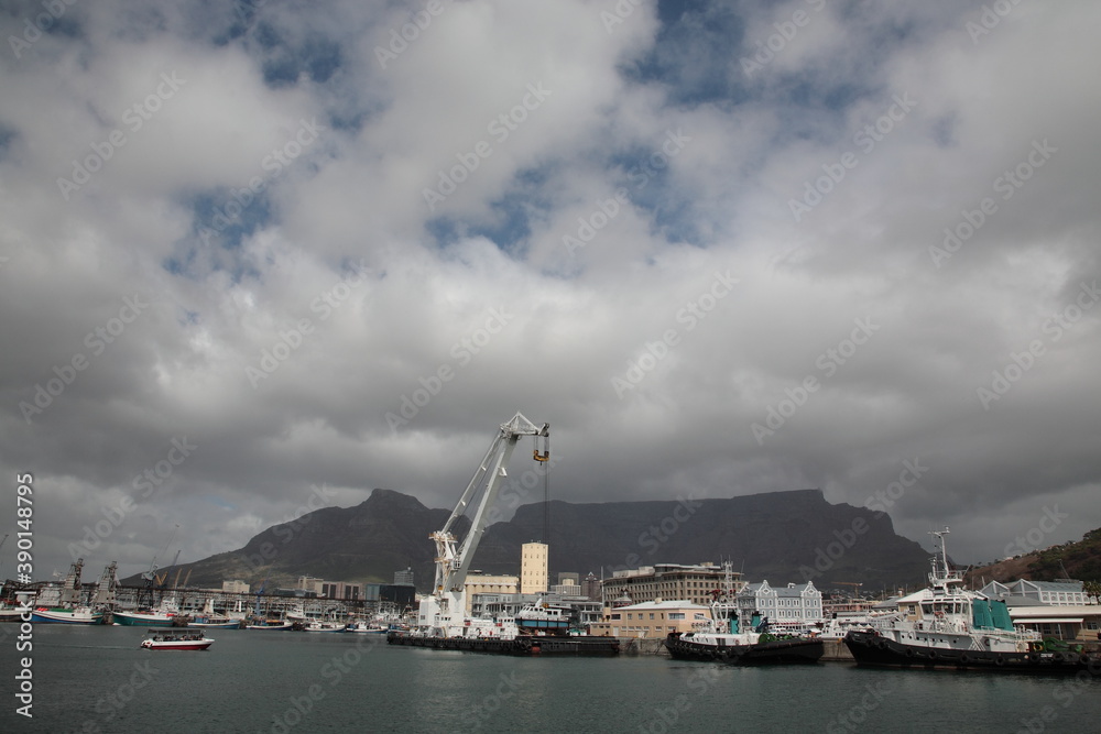 View of Victoria and Alfred Waterfront with table mountain under blue sky at Table Bay Harbour in Cape Town, South Africa