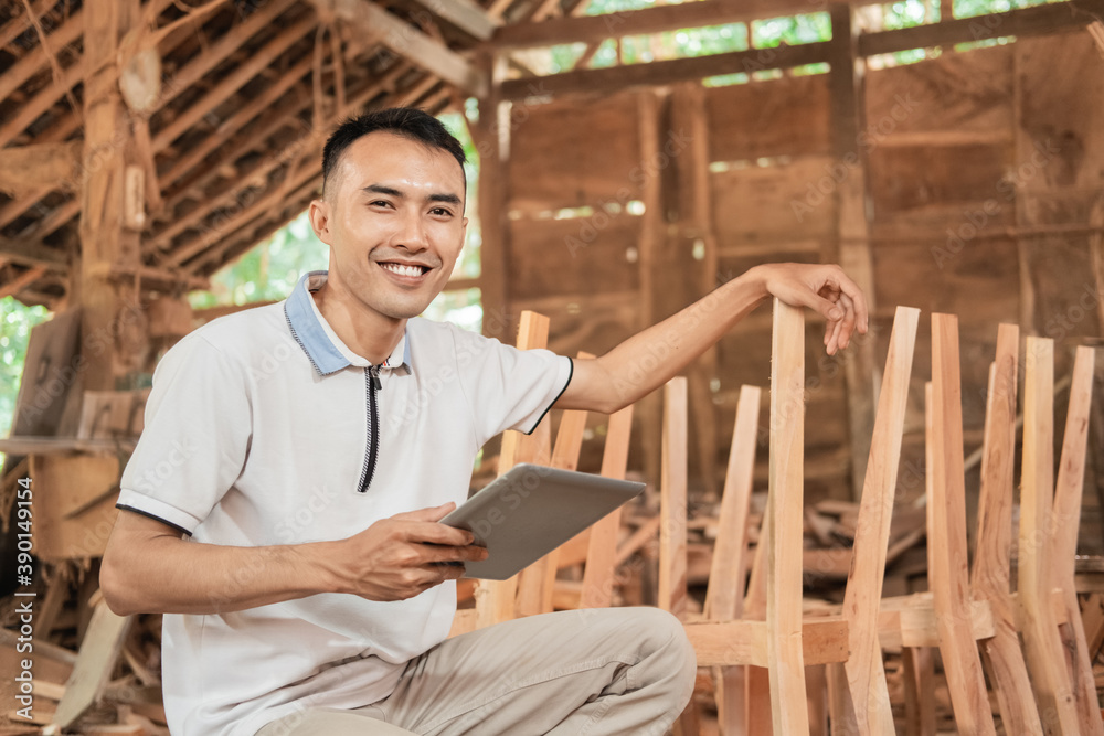 successful young entrepreneurs smile while sitting using a tablet pc in a furniture workshop