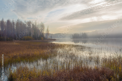 Autumn, foggy morning, over the lake, in the distance you can see a small island. Finland, Scandinavian nature.