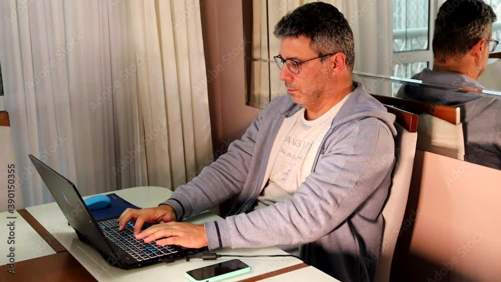 Home em home office usando celular e notebook
