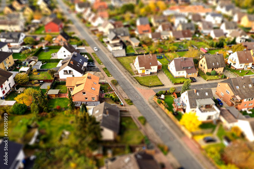 Suburb with family houses, front gardens and afterban, aerial view with tilt shift effect photo
