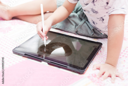 Kid using technology to write and draw expressing their creativity. A concept of digital learning.