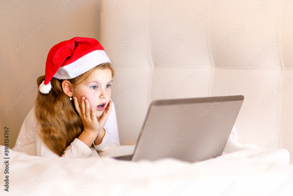 Christmas time concept. Young teen girl with tablet pc laptop on sofa at home doing online shopping, buying browsing for gifts, having surprise Christmas time concept. Young teen girl with tablet pc laptop on sofa at home doing online shopping, buying browsing for gifts, having surprise