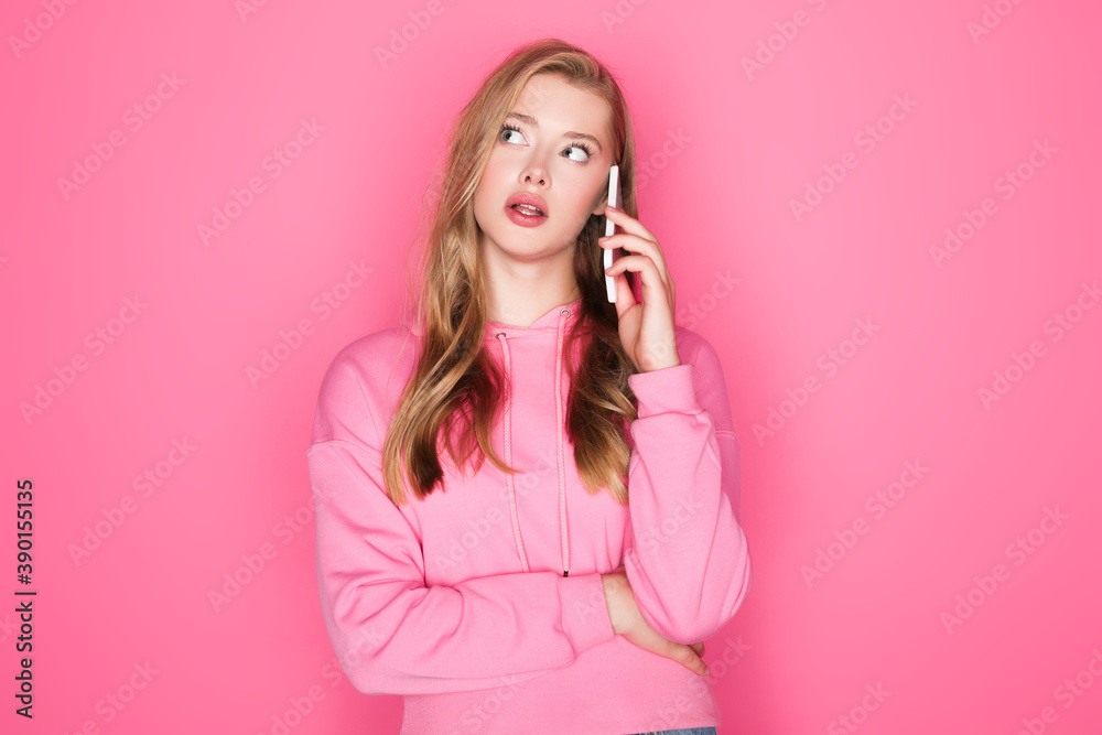 pensive beautiful woman talking on smartphone on pink background pensive beautiful woman talking on smartphone on pink background