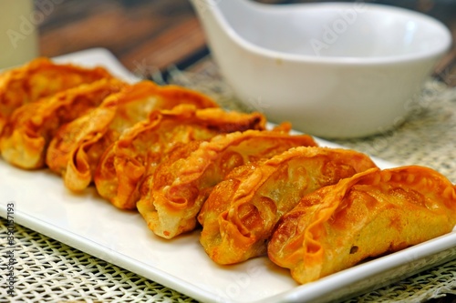 Pan fried Chinese dumplings (Jiaozi, Gyoza) in white plate ready to serve.