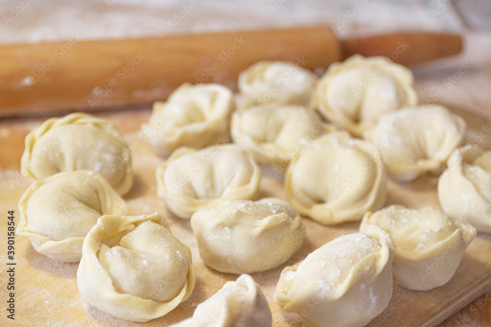 Closeup on semi-finished pelmeni dumplings on the wooden board. Closeup on semi-finished pelmeni dumplings on the wooden board.