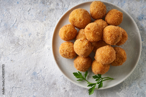 Fried cheese balls, appetizer with herbs and sauces in a plate on a gray table Copyspace
