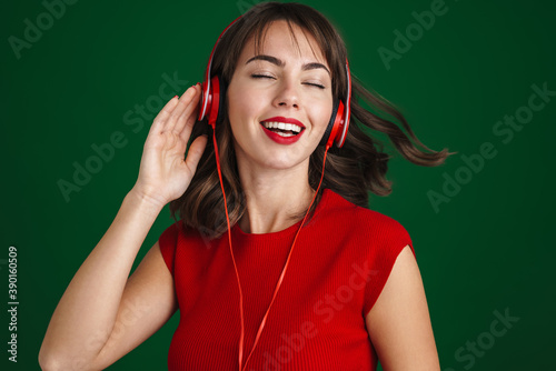 Beautiful happy girl listening music with headphones and dancing