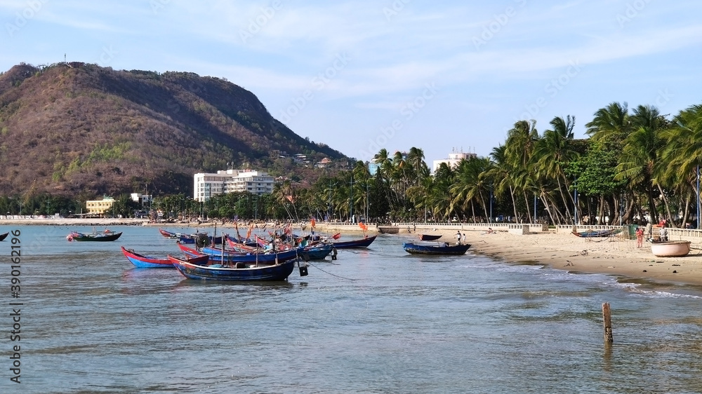 Obraz premium Fishing boats near Front Beach. Coastline of Vung Tau. Sea, palm trees and hill. Vietnam. South-East Asia